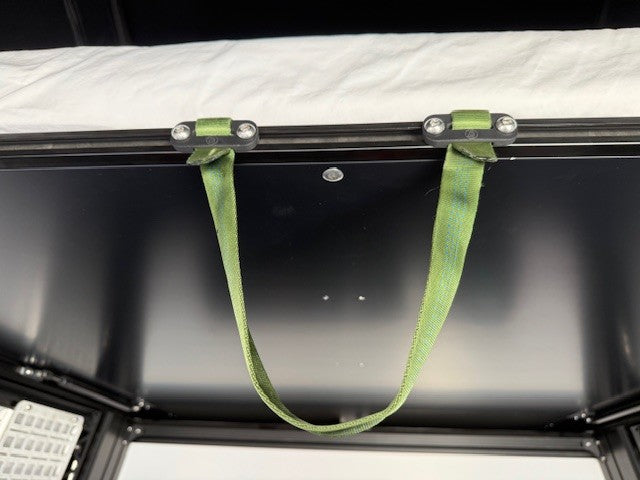 Green strap attached to a metallic surface with a reflective background