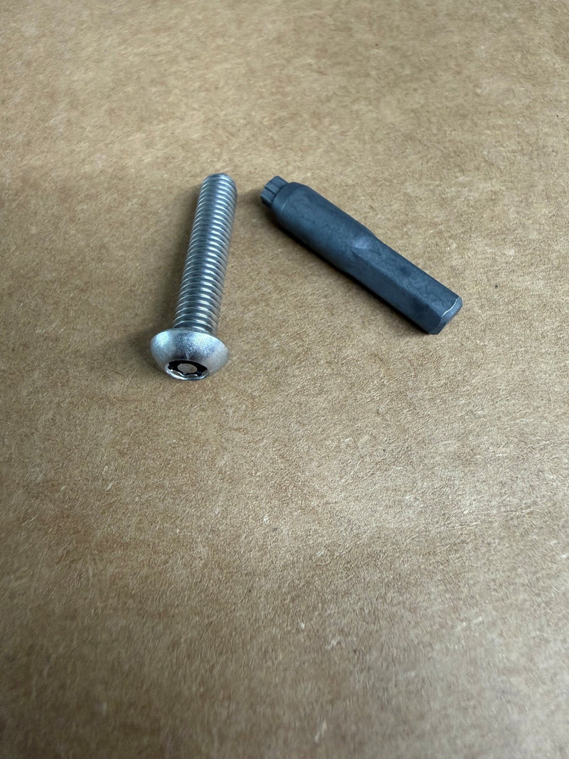 A silver metal threaded screw bolt and a dark gray hexagonal plastic or rubber insert placed on a brown textured cardboard background.
