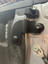 Textured black powder-coated brackets attached to a vehicle's tailgate, designed to protect the tailgate and tail lights.