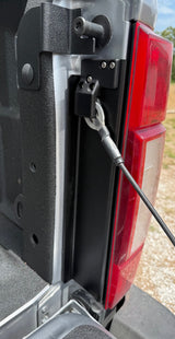 Black brackets installed on bedpost with taillight and grass in the background
