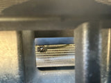Peeking through the grill to show bottom of black bracket when installed, connector visible