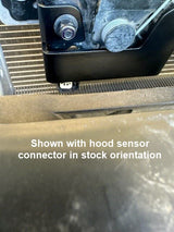 Black bracket installed with words stating "shown with hood sensor connector in stock orientation"