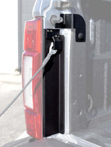 Black brackets installed on a truck bed post