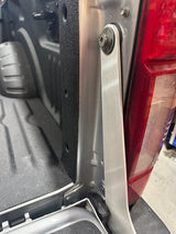 Aluminum bracket installed on truck with bed post and taillight in background